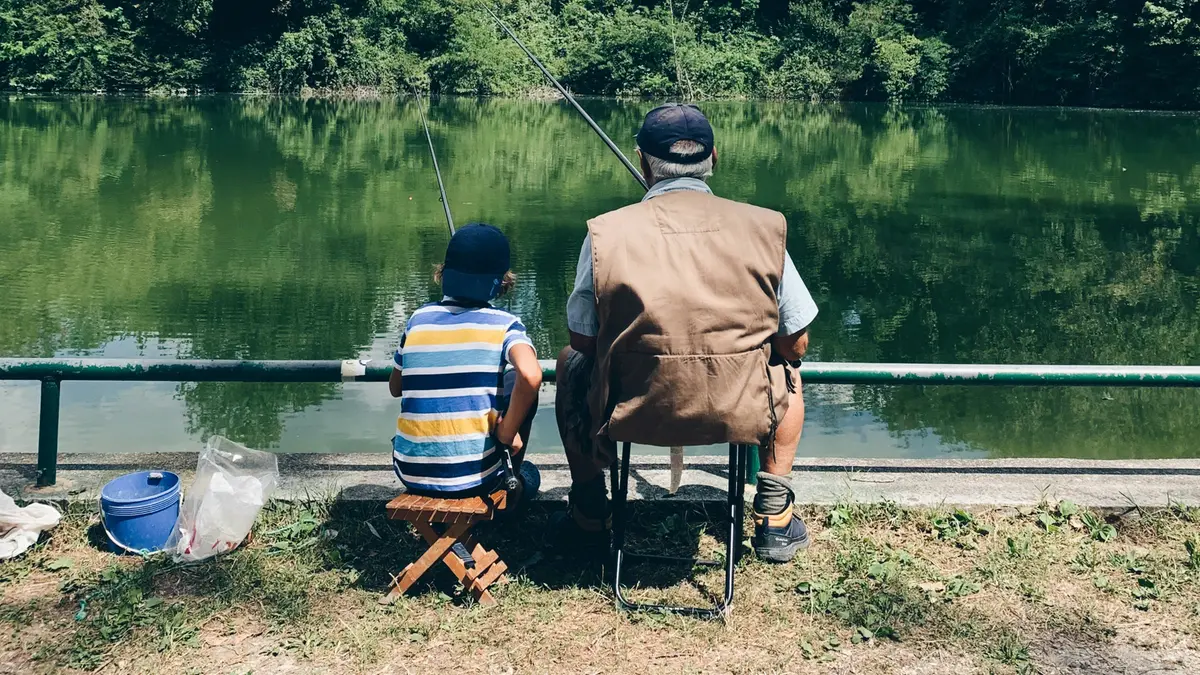 Nonno e nipote pescano in un laghetto