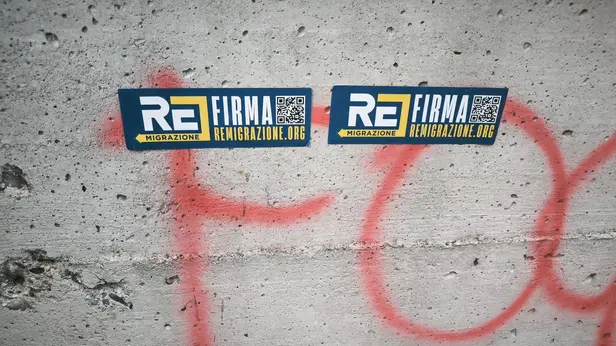 Gli adesivi sulla remigrazione e contro la mosche a Brescia