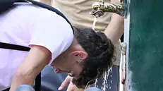 Un ragazzo si rinfresca a una fontanella