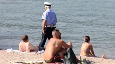 Controlli della polizia locale di Como per far rispettare il divieto di balneazione sulla spiaggia che si è creata nei pressi del tempio Voltiano a Como a causa dei sedimenti e del livello delle acque. In questo tratto la scorsa settimana sono annegati due ragazzi. Como 24 Agosto 2023 ANSA / MATTEO BAZZI