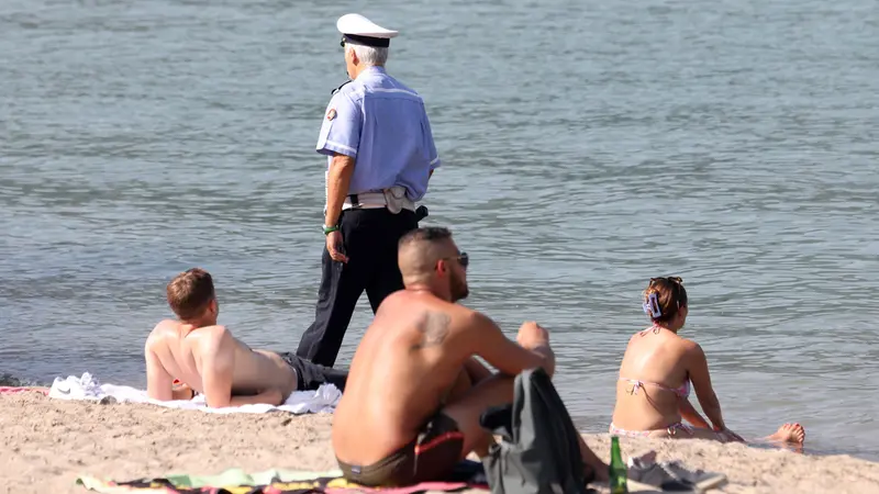 Controlli della polizia locale di Como per far rispettare il divieto di balneazione sulla spiaggia che si è creata nei pressi del tempio Voltiano a Como a causa dei sedimenti e del livello delle acque. In questo tratto la scorsa settimana sono annegati due ragazzi. Como 24 Agosto 2023 ANSA / MATTEO BAZZI
