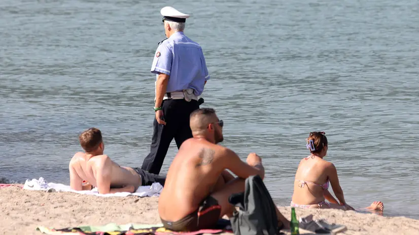 Controlli della polizia locale di Como per far rispettare il divieto di balneazione sulla spiaggia che si è creata nei pressi del tempio Voltiano a Como a causa dei sedimenti e del livello delle acque. In questo tratto la scorsa settimana sono annegati due ragazzi. Como 24 Agosto 2023 ANSA / MATTEO BAZZI