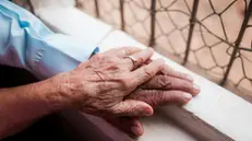 Le mani di due persone anziane