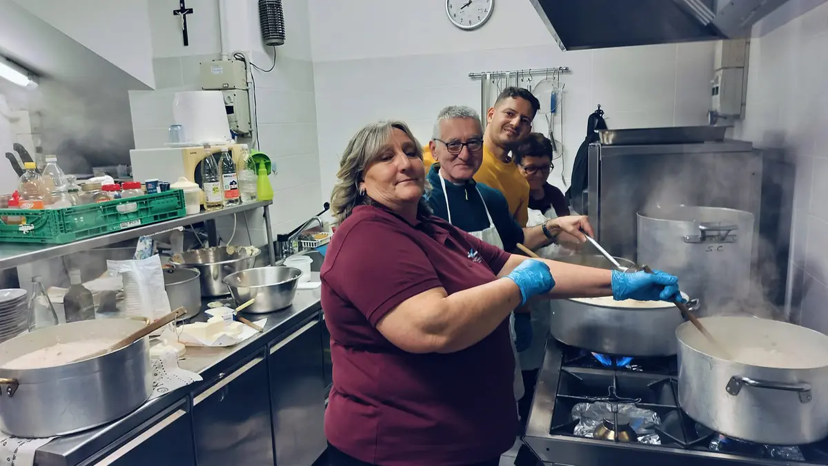 Alcuni volontari mentre preparano i pasti caldi agli ospiti