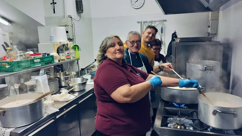 Alcuni volontari mentre preparano i pasti caldi agli ospiti