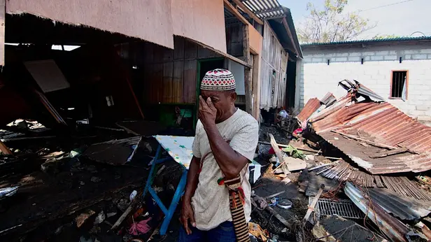 Un uomo disperato fuori da una casa distrutta dal terremoto in Indonesia - Foto Ansa © www.giornaledibrescia.it
