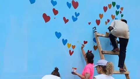 I cuori colorati realizzati sulla parete azzurra della scuola