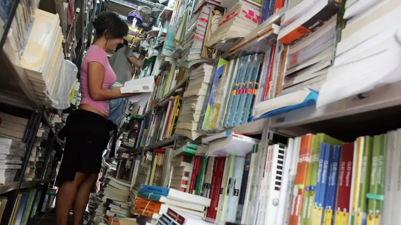 Una ragazza tra scaffali di libri scolastici - Foto Ansa © www.giornaledibrescia.it