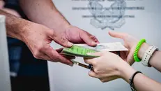 La consegna di una scheda elettorale durante le operazioni di voto - Foto Ansa © www.giornaledibrescia.it