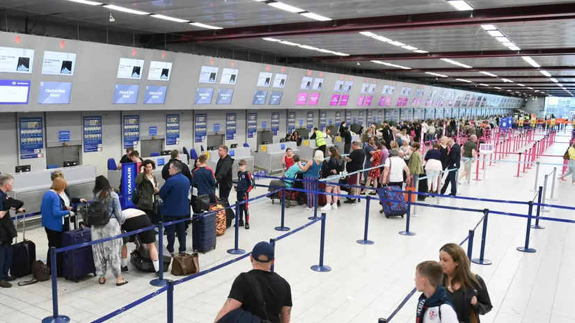 Viaggiatori al check-in in un aeroporto