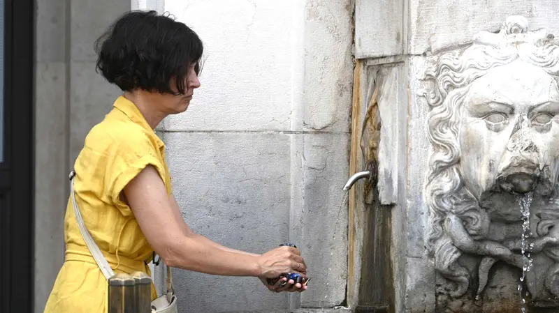 Una donna si rinfresca in una fontana di Brescia - Foto Marco Ortogni/Neg © www.giornaledibrescia.it