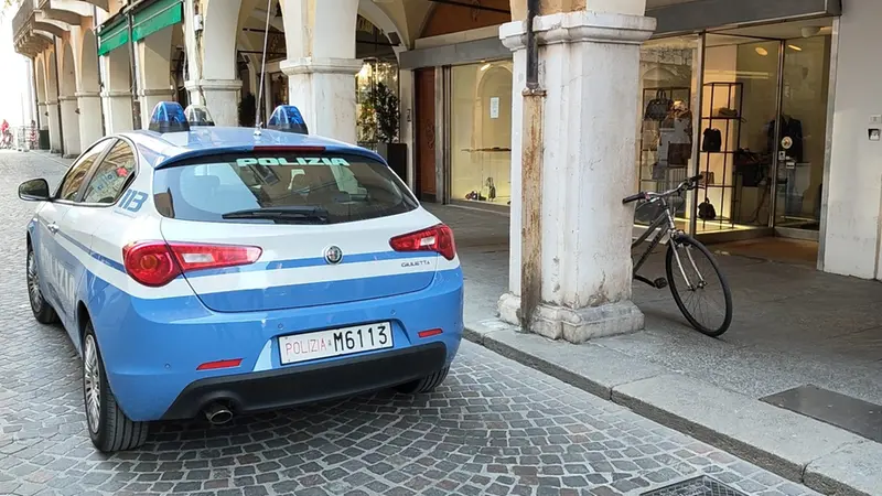 Un'auto della Polizia in via X Giornate, dove martedì è stato aggredito un commerciante