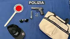 La finta pistola e altri oggetti sequestrati al malvivente