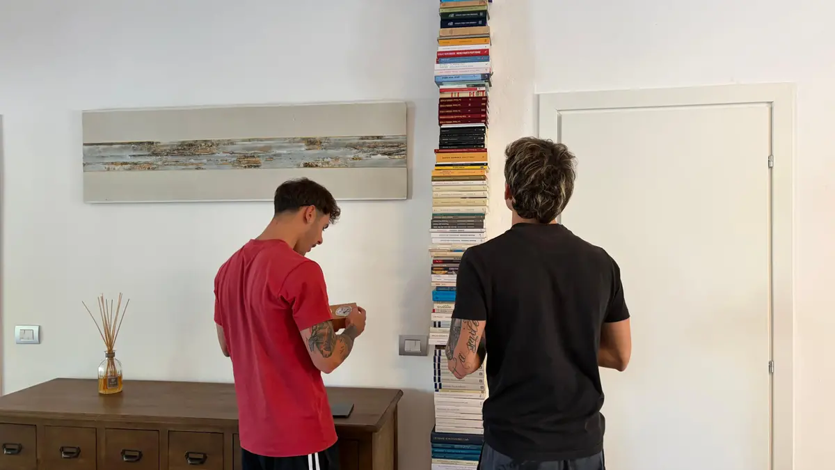 I due gemelli davanti ai libri nella canonica della parrocchia che li ospita - © www.giornaledibrescia.it
