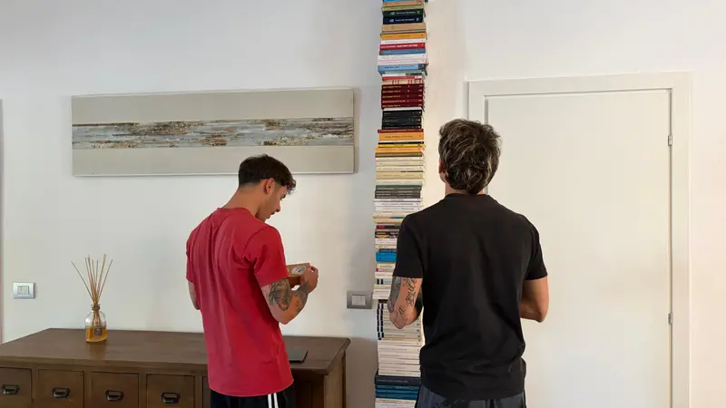 I due gemelli davanti ai libri nella canonica della parrocchia che li ospita - © www.giornaledibrescia.it