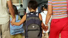 Un bambino accompagnato a scuola dai genitori - Foto Ansa © www.giornaledibrescia.it