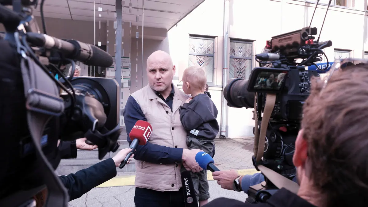 Il primo ministro lettone Andris Kulbergs con suo figlio davanti alle telecamere dopo aver votato - Foto Ansa © www.giornaledibrescia.it