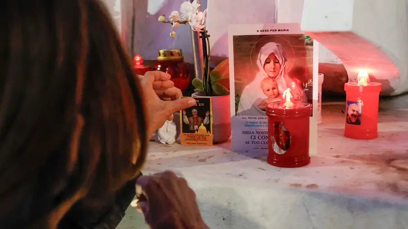 Una donna in preghiera per il papa - Foto Ansa © www.giornaledibrescia.it