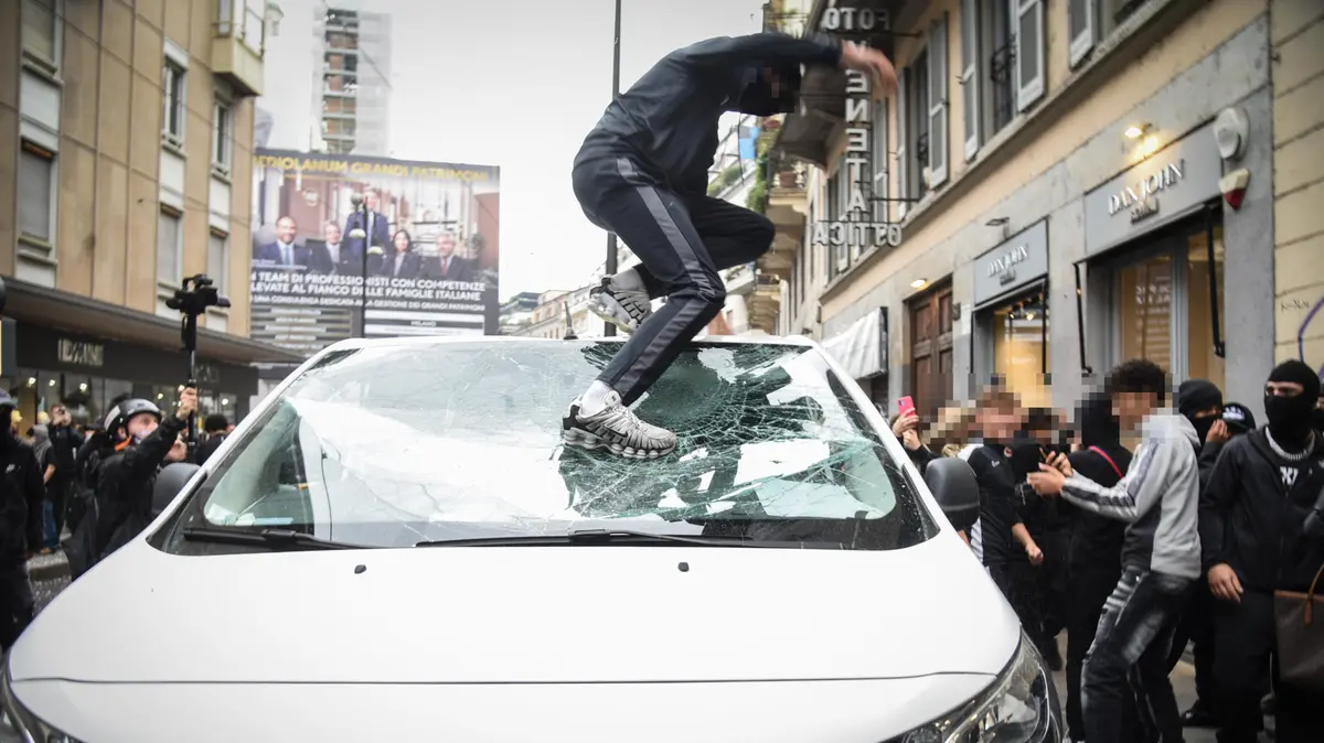 Un ragazzo distrugge un'auto a Milano - Foto Ansa © www.giornaledibrescia.it