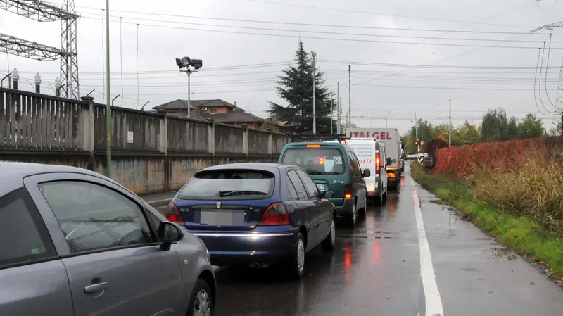 Auto in coda davanti al passaggio a livello di via Ziziola - © www.giornaledibrescia.it